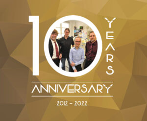 das Bild zeigt eine 10 umramt mit den Worten Years und Anniversary 2012 - 2022. In der Mitte der Null ist ein Foto mit den 4 Gründern der Firma Yumab GmbH zu sehen