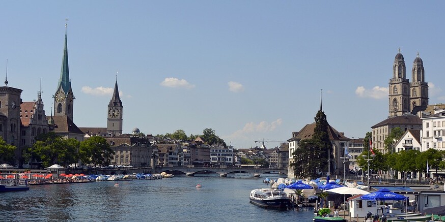 Stadtpanorama von Zürich mit Kirchen und Fluss.